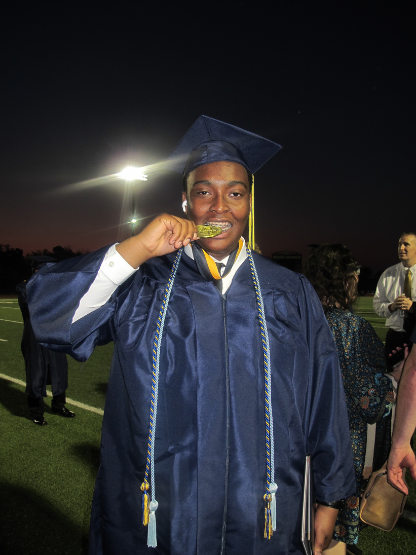 Richard biting his graduation medal